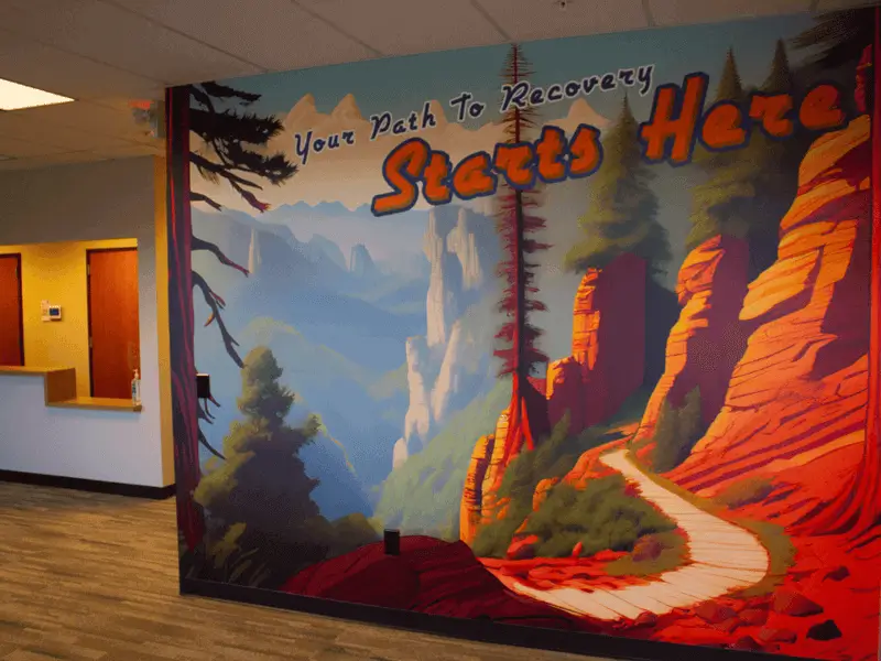 A large mural of a landscape on the wall of the front lobby inside the center