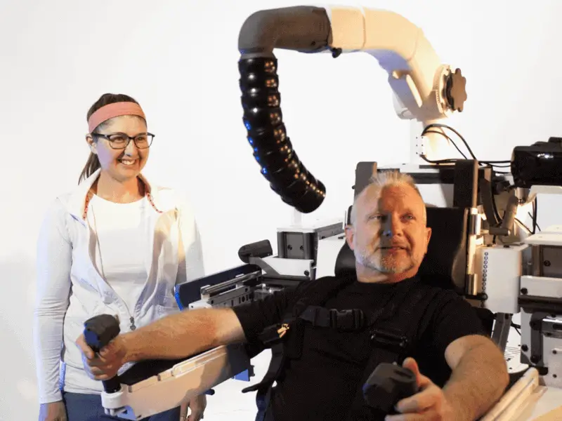 A man sitting in the OutbounderARS platform with the machine operator smiling next to him